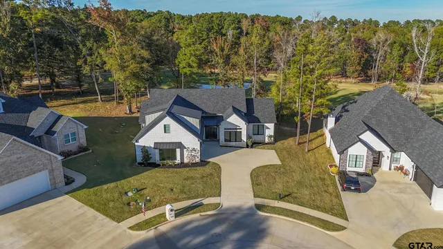an aerial view of a house with swimming pool and porch
