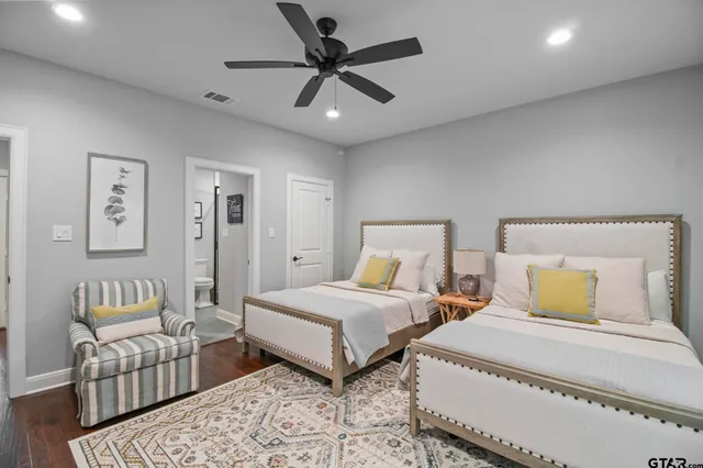 a bedroom with two beds and painting on the wall