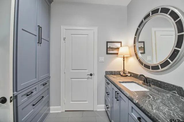 a bathroom with a granite countertop sink and a mirror