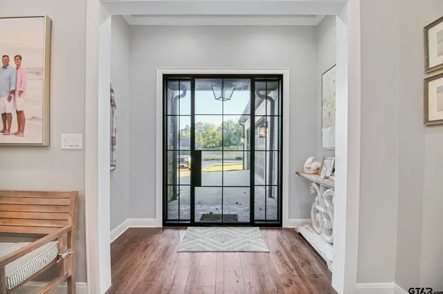 a view of a hallway with wooden floor and a living room