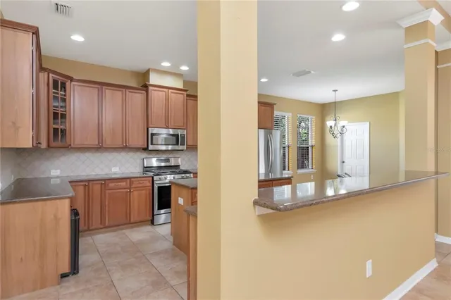 a kitchen with stainless steel appliances granite countertop a refrigerator and a stove top oven