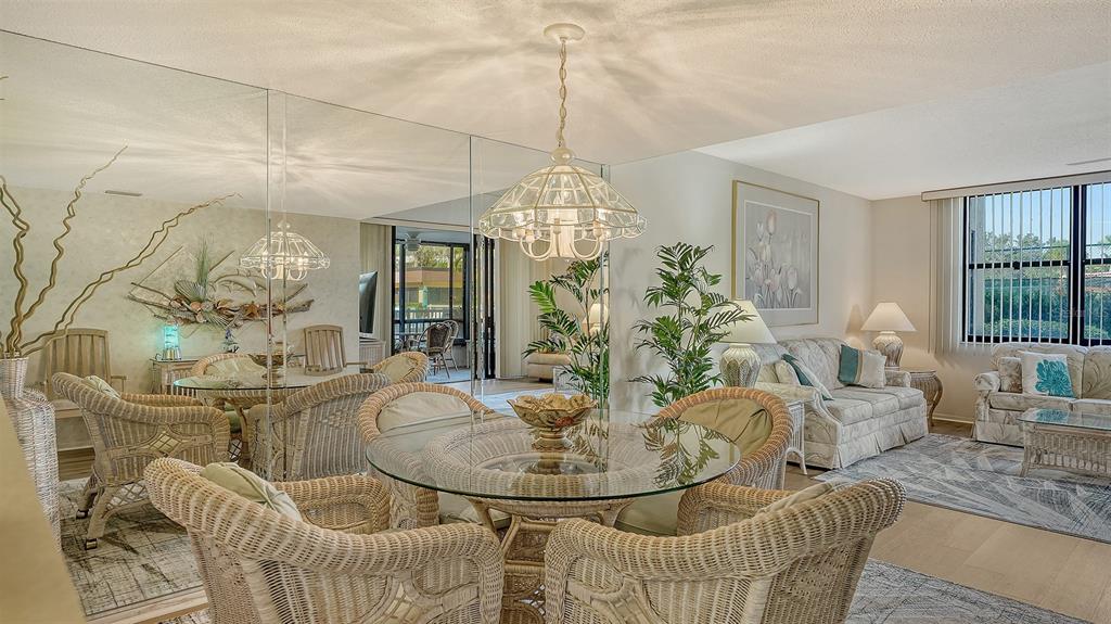 8773 Midnight Pass Road, Unit 102G Sarasota, FL 34242 - Photo 15 of 79 a dining room with furniture a chandelier and kitchen view
