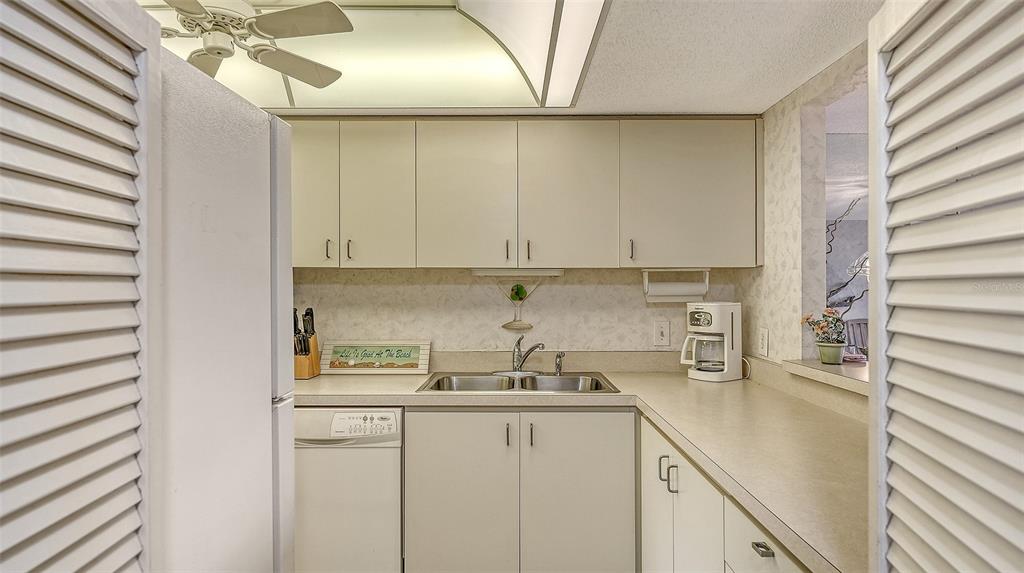 8773 Midnight Pass Road, Unit 102G Sarasota, FL 34242 - Photo 18 of 79 a kitchen with a sink and cabinets