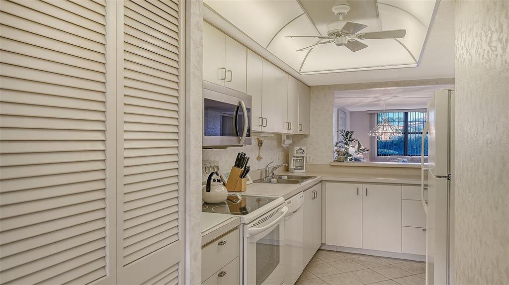 8773 Midnight Pass Road, Unit 102G Sarasota, FL 34242 - Photo 21 of 79 a kitchen with stainless steel appliances white cabinets a sink a stove and a window