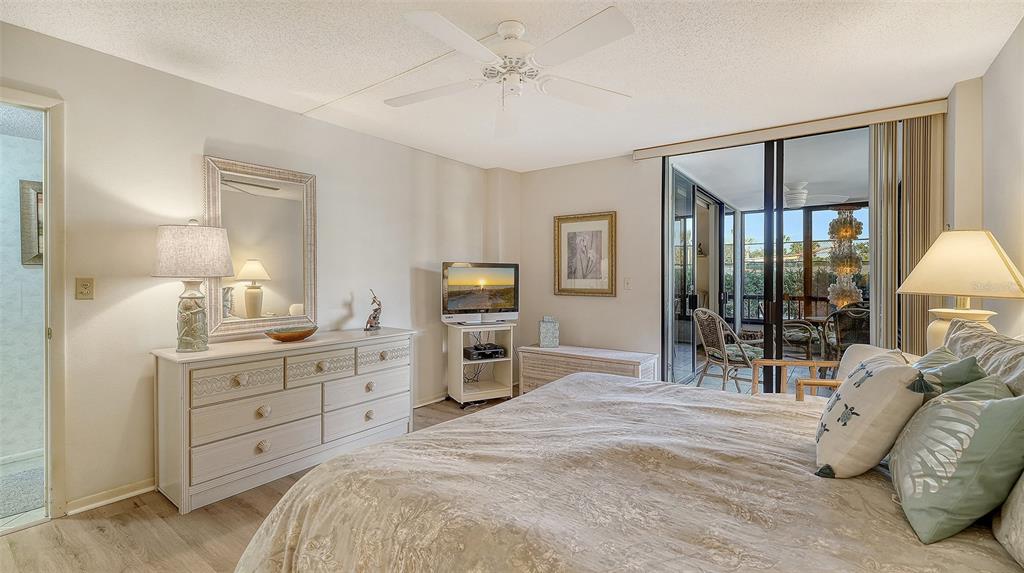 8773 Midnight Pass Road, Unit 102G Sarasota, FL 34242 - Photo 24 of 79 a bedroom with a bed and a chandelier