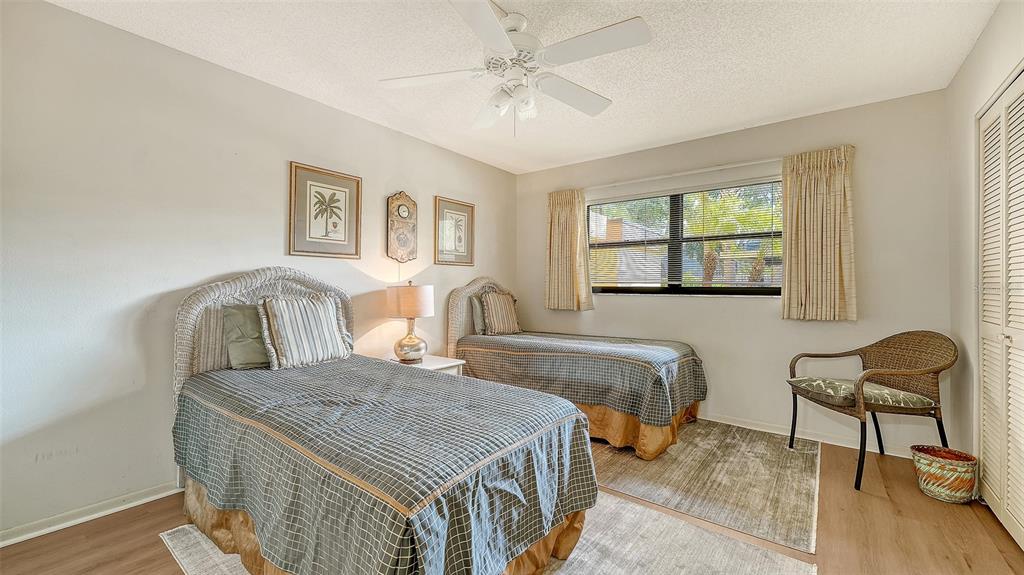 8773 Midnight Pass Road, Unit 102G Sarasota, FL 34242 - Photo 31 of 79 a bedroom with a bed and wooden floor