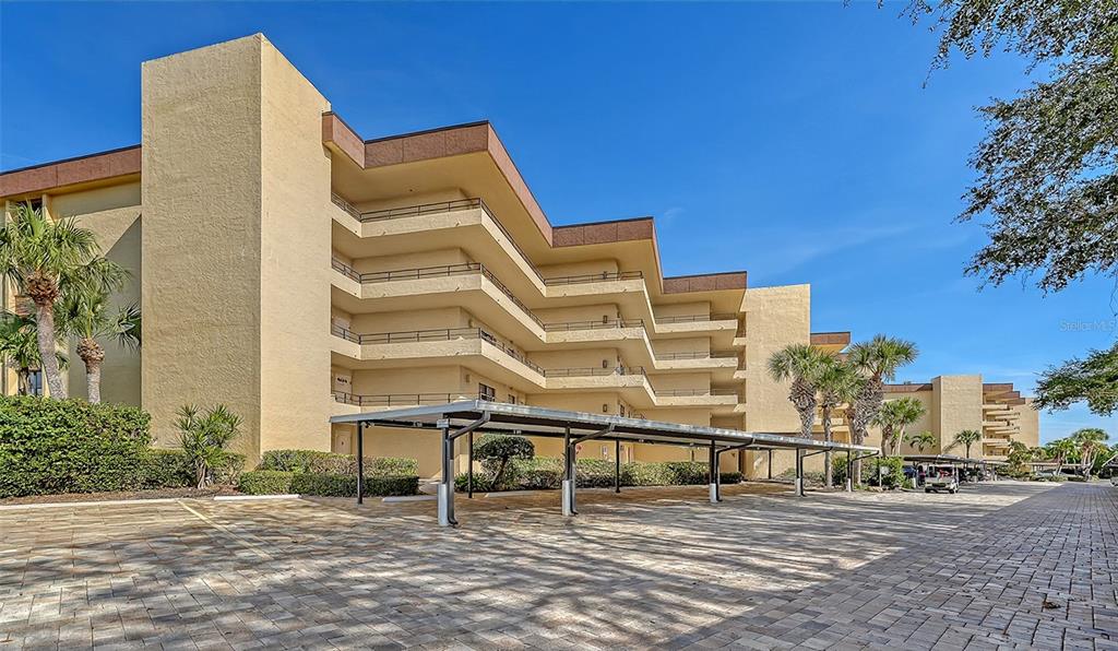 8773 Midnight Pass Road, Unit 102G Sarasota, FL 34242 - Photo 5 of 79 a blue bench sitting in front of a building