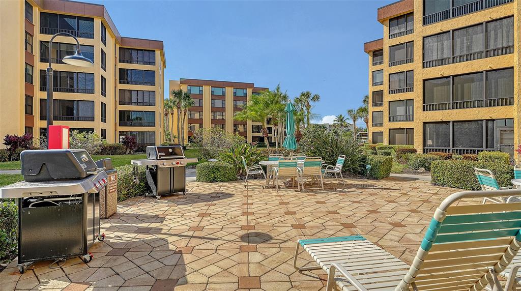 8773 Midnight Pass Road, Unit 102G Sarasota, FL 34242 - Photo 53 of 79 a view of a patio with table and chairs and potted plants