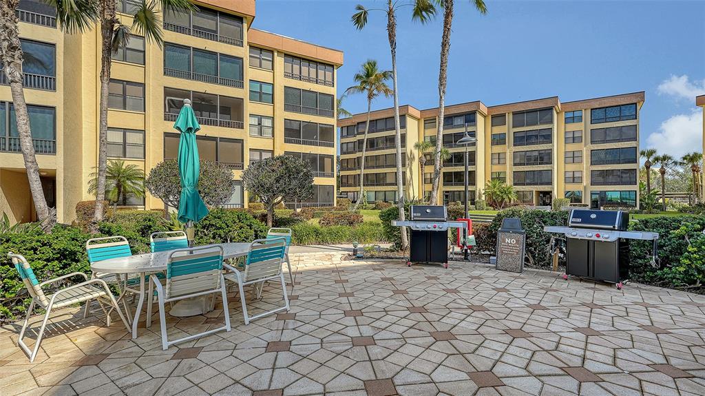 8773 Midnight Pass Road, Unit 102G Sarasota, FL 34242 - Photo 58 of 79 a view of a patio with table and chairs and potted plants