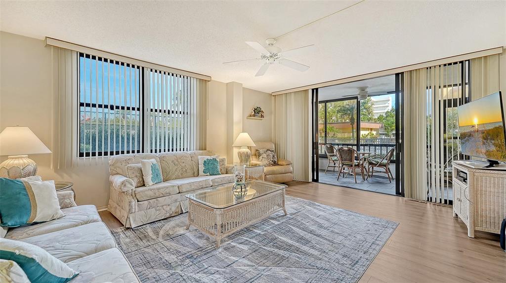 8773 Midnight Pass Road, Unit 102G Sarasota, FL 34242 - Photo 9 of 79 a living room with furniture and a floor to ceiling window
