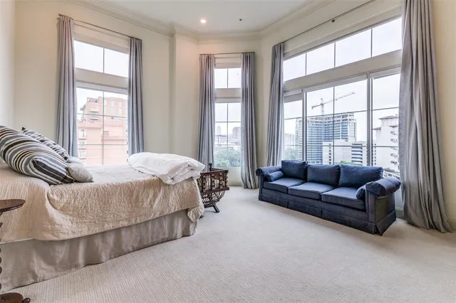 a spacious bedroom with large bed and a couch next to a window