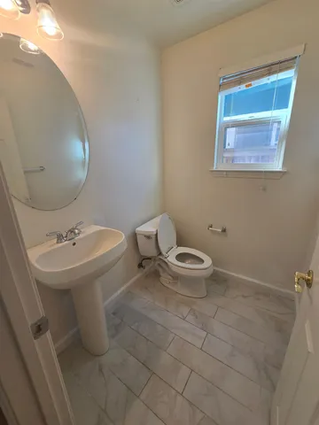 a bathroom with a sink a toilet and mirror