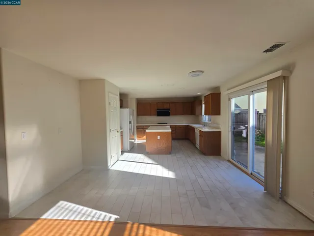 a large open kitchen with a refrigerator a counter top space and a sink