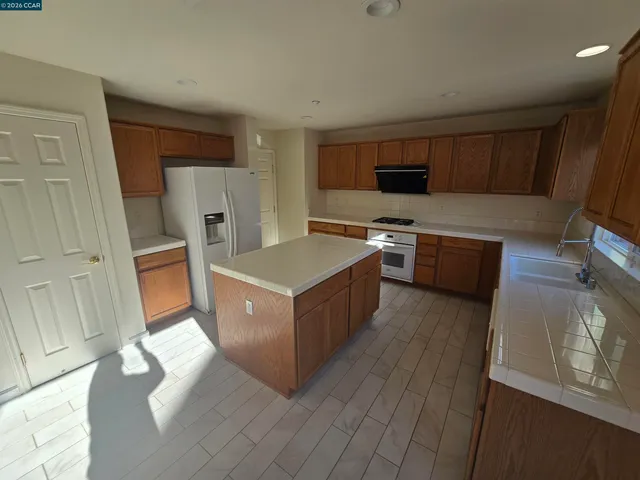 a kitchen with stainless steel appliances a stove a sink and a refrigerator