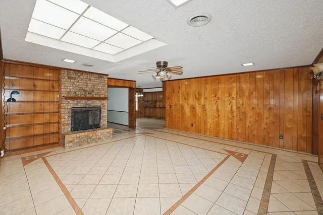 a view of an empty room with a fireplace and a window