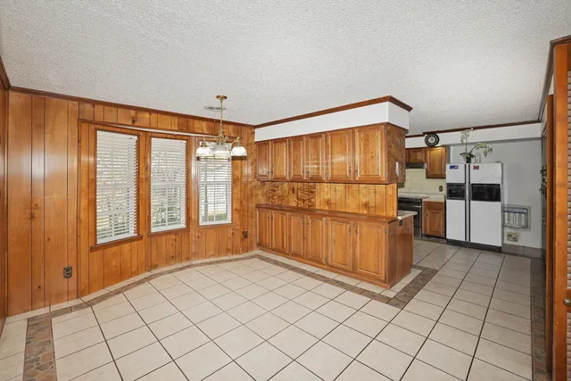 a kitchen with granite countertop a refrigerator and a stove top oven