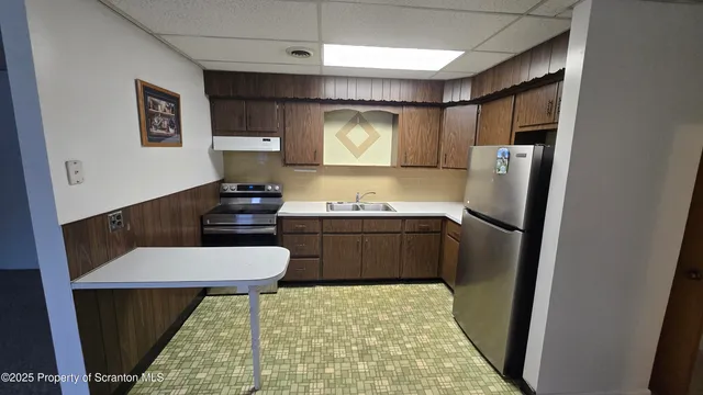 a kitchen with stainless steel appliances a refrigerator and a stove