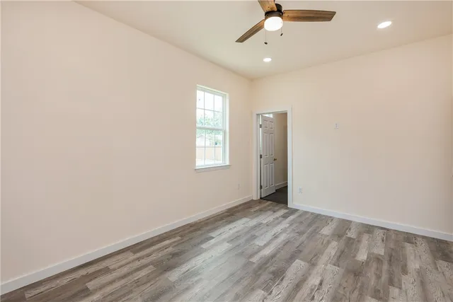 an empty room with a window and a fan