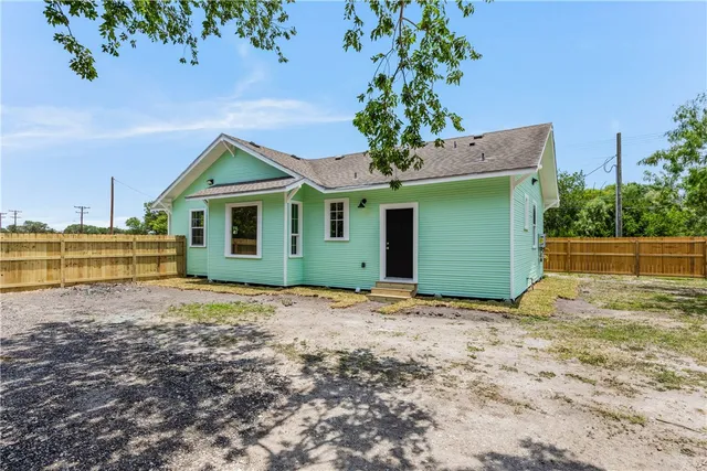 a view of a yard with wooden fence
