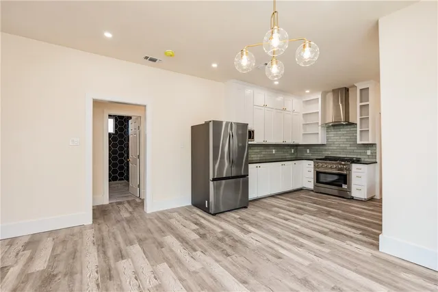 a kitchen with stainless steel appliances granite countertop a refrigerator and a sink