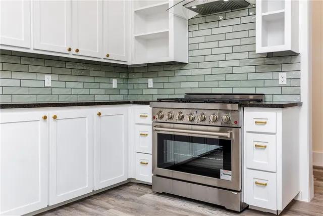 a kitchen with granite countertop cabinets stainless steel appliances and a wooden floor