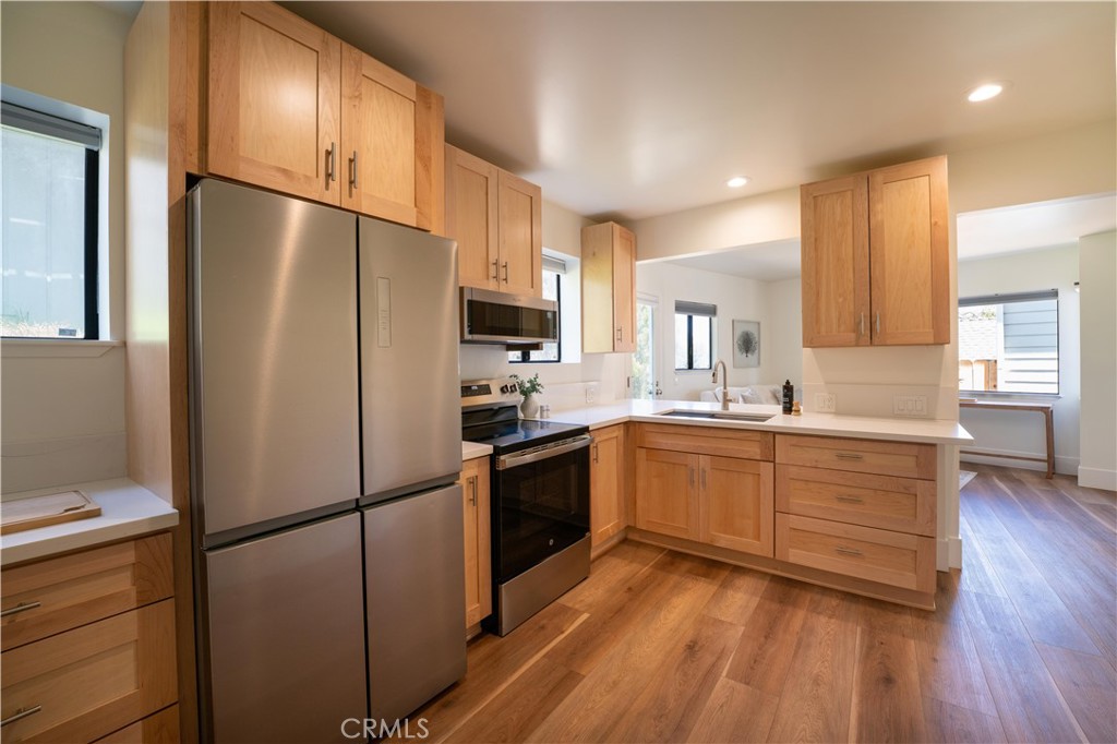 675 Huntington Road Cambria, CA 93428 - Photo 26 of 30 a kitchen with a refrigerator a sink cabinets and wooden floor