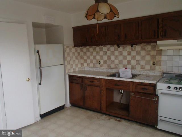 7651 Charlesmont Road Baltimore, MD 21222 - Photo 4 of 17 a kitchen with stainless steel appliances a stove and a refrigerator