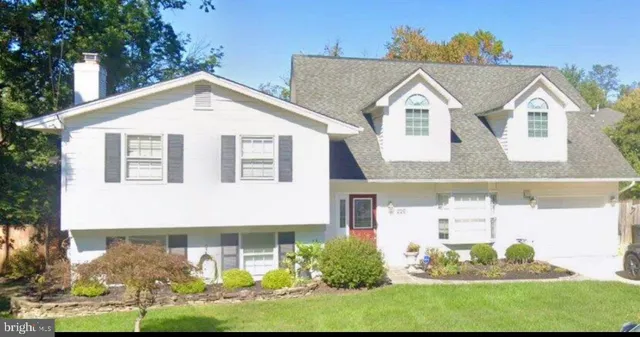 a view of a white house next to a yard