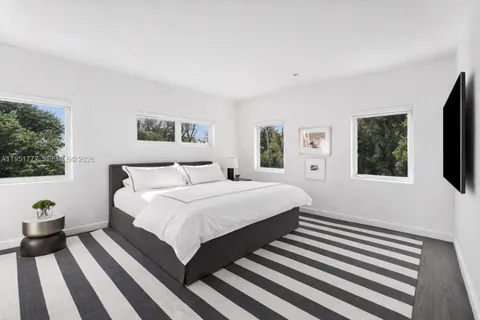 a bedroom with a large bed and a flat screen tv