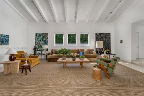 a living room with furniture and large windows