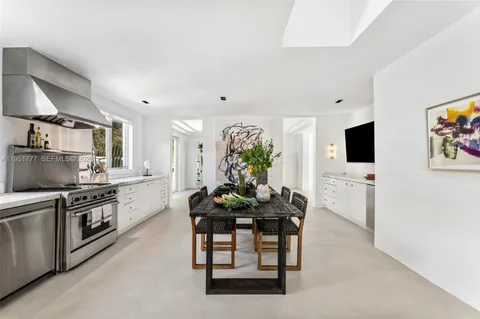 a kitchen with stainless steel appliances a table and chairs in it
