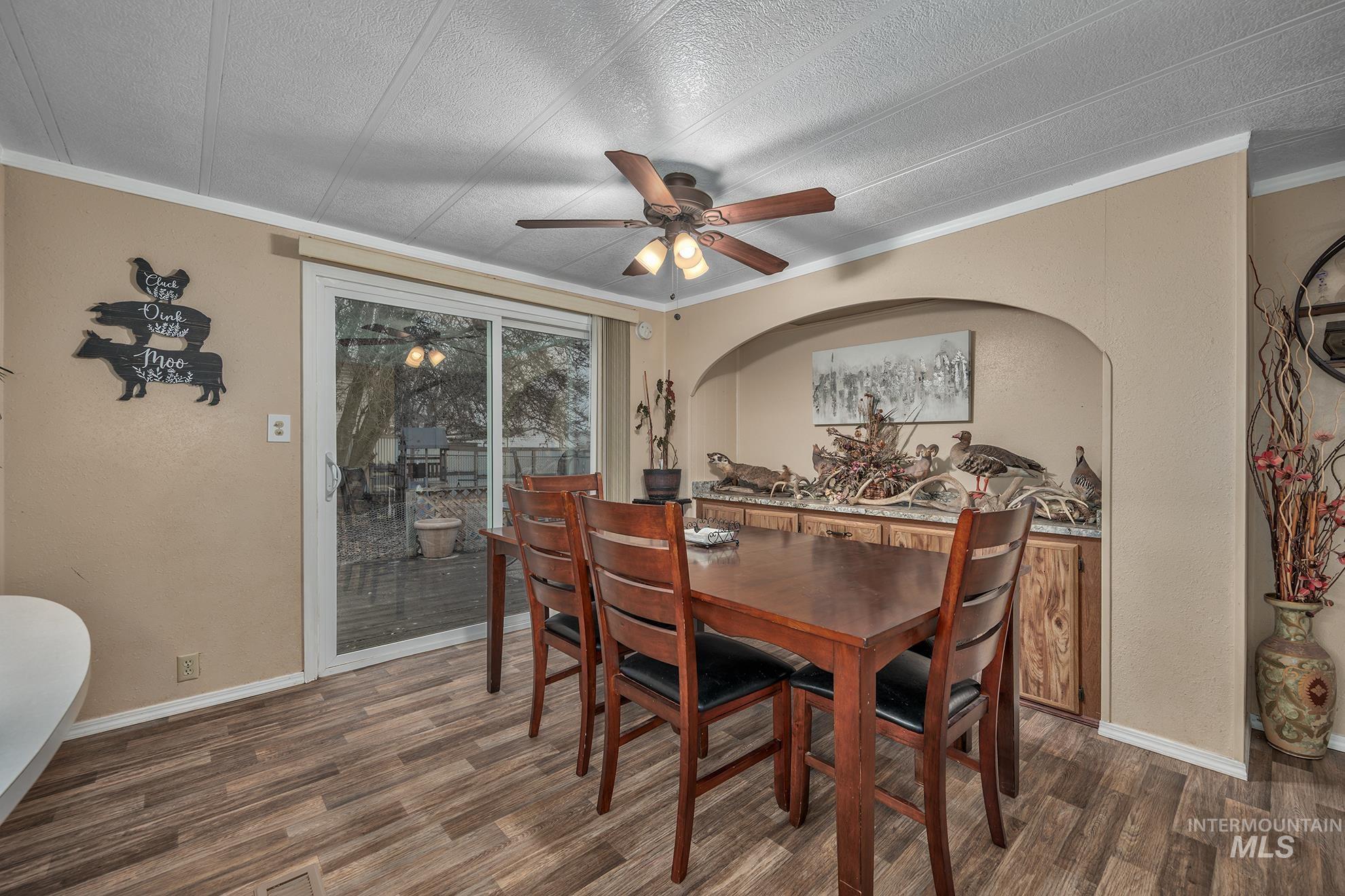 1165 Pioneer Road Weiser, ID 83672 - Photo 14 of 24 Dining area featuring crown molding, wood finished floors, a ceiling fan, and a textured ceiling