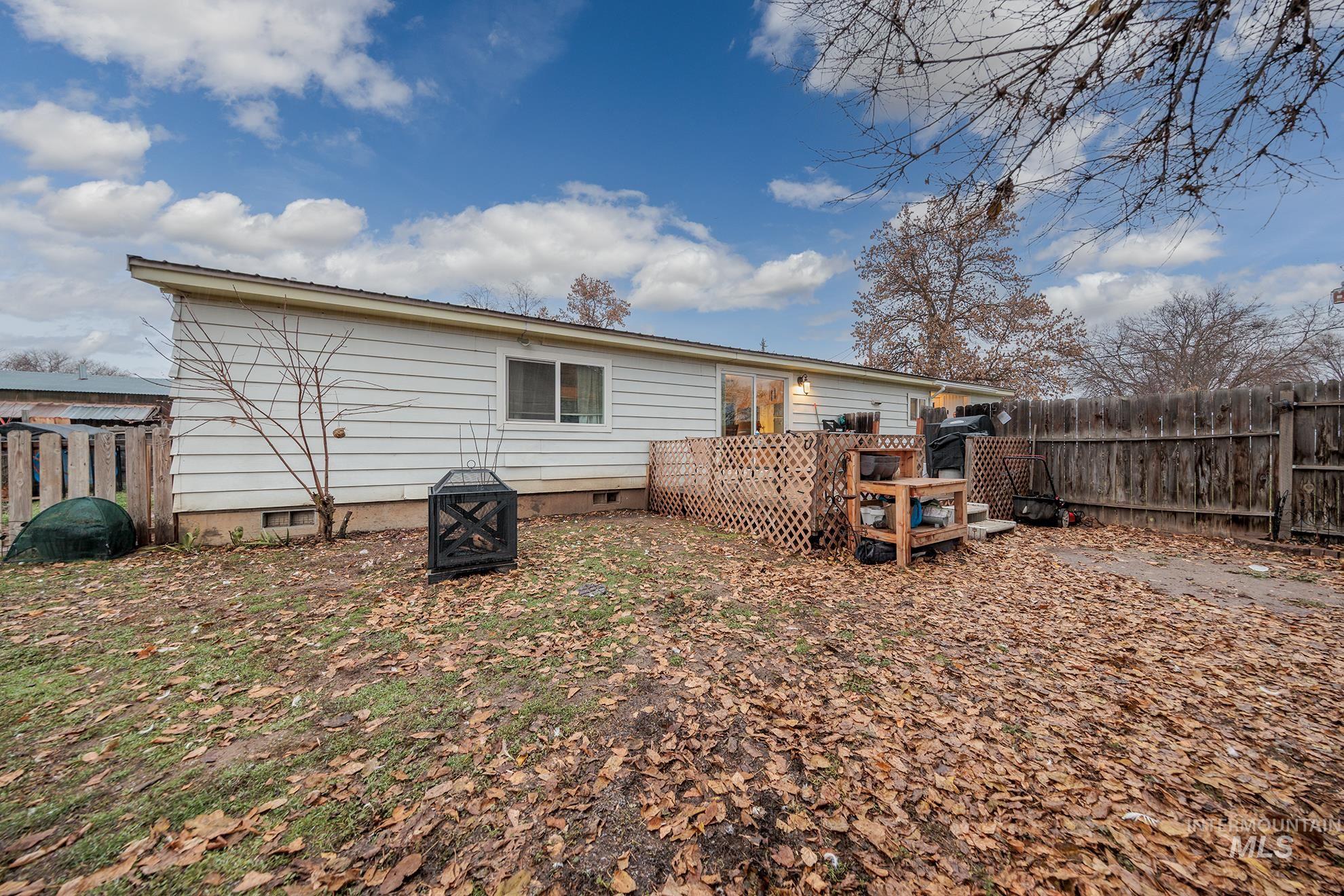 1165 Pioneer Road Weiser, ID 83672 - Photo 6 of 24 Rear view of house with crawl space, a wooden deck, and an outdoor fire pit