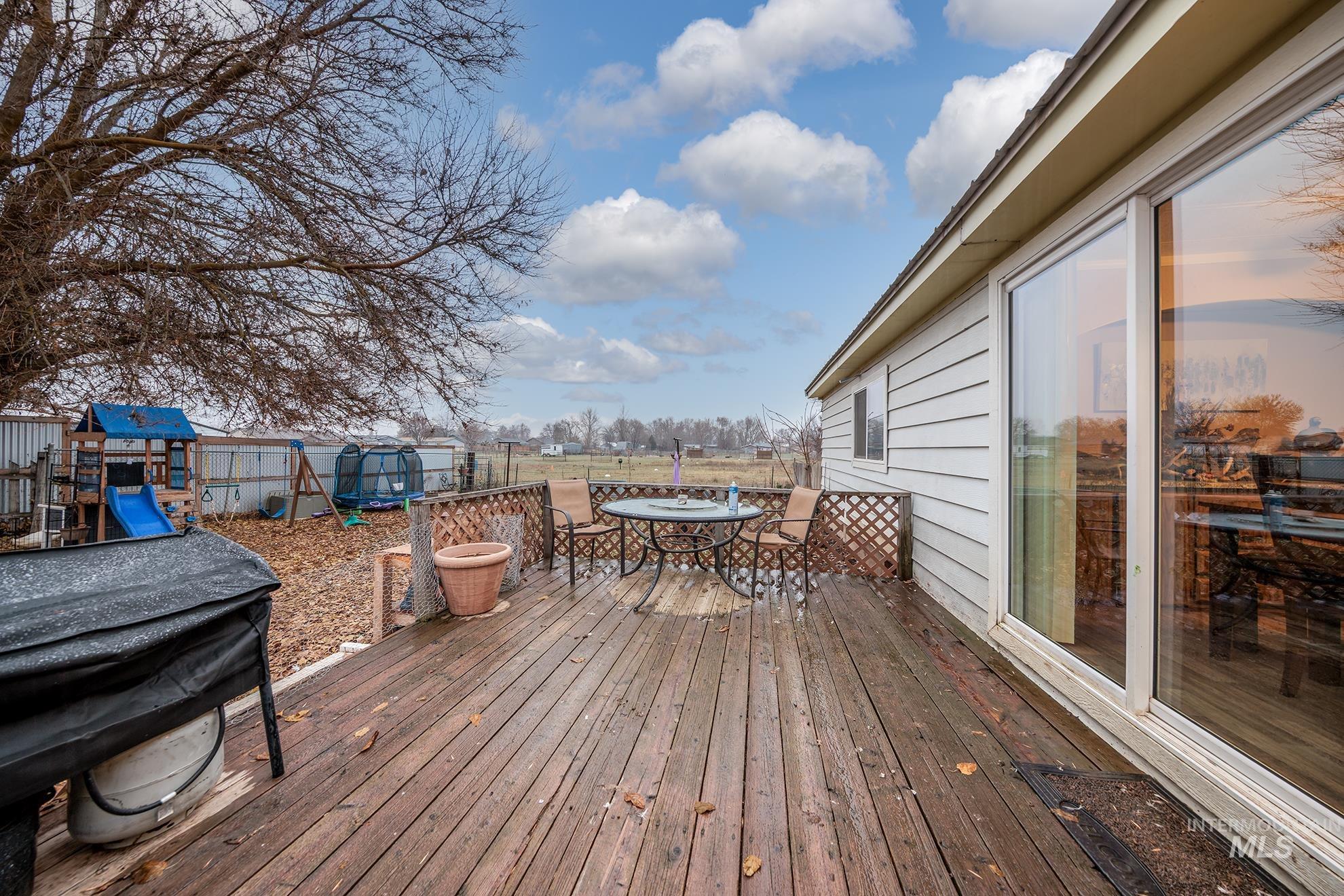 1165 Pioneer Road Weiser, ID 83672 - Photo 7 of 24 Deck with outdoor dining space and a playground
