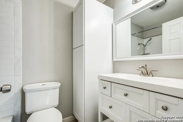 a bathroom with a toilet sink and mirror