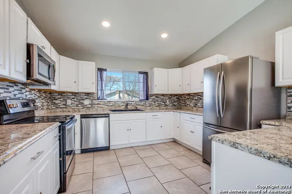 a kitchen with granite countertop cabinets stainless steel appliances and a counter space