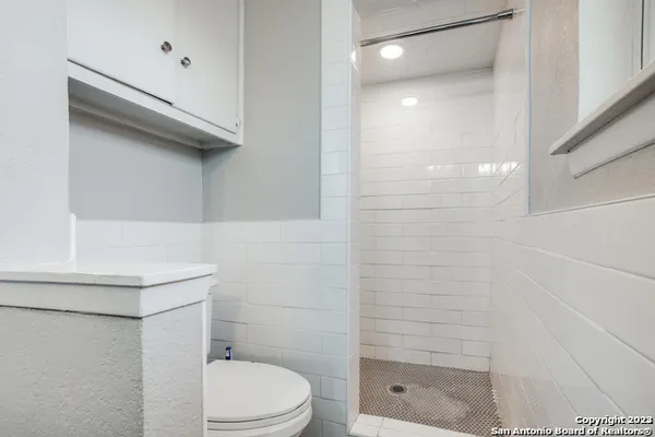 a bathroom with a shower a toilet and a shower