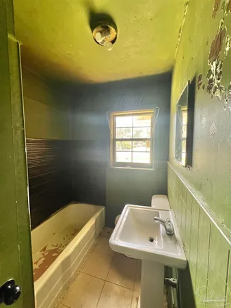 a bathroom with a toilet a sink and mirror