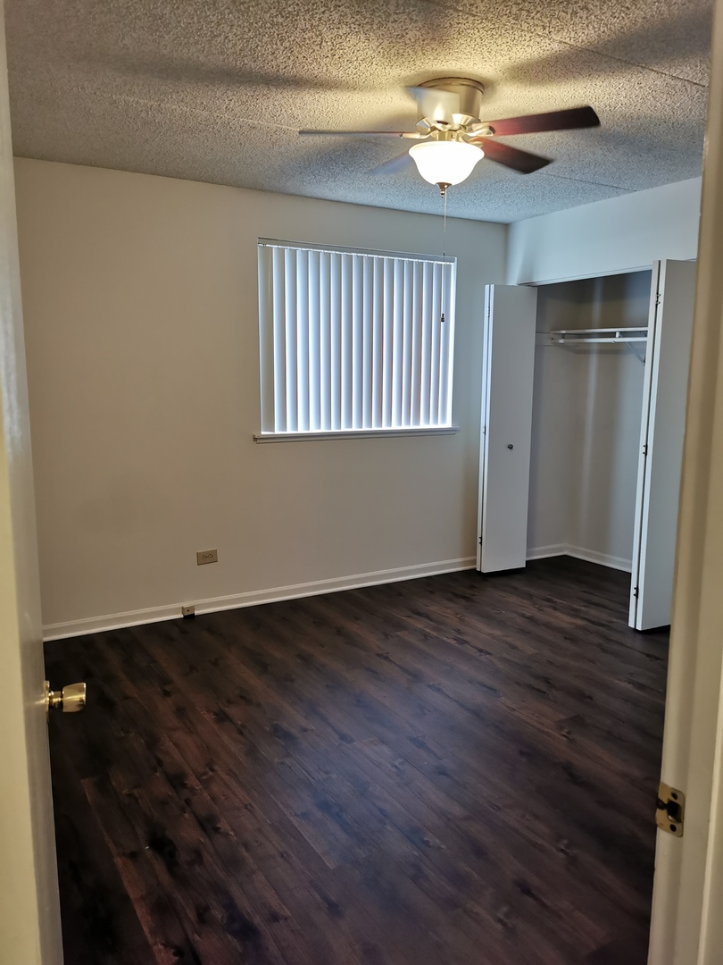 1424 Rock Run Drive, Unit B1 Crest Hill, IL 60403 - Photo 11 of 14 wooden floor in an empty room with a window