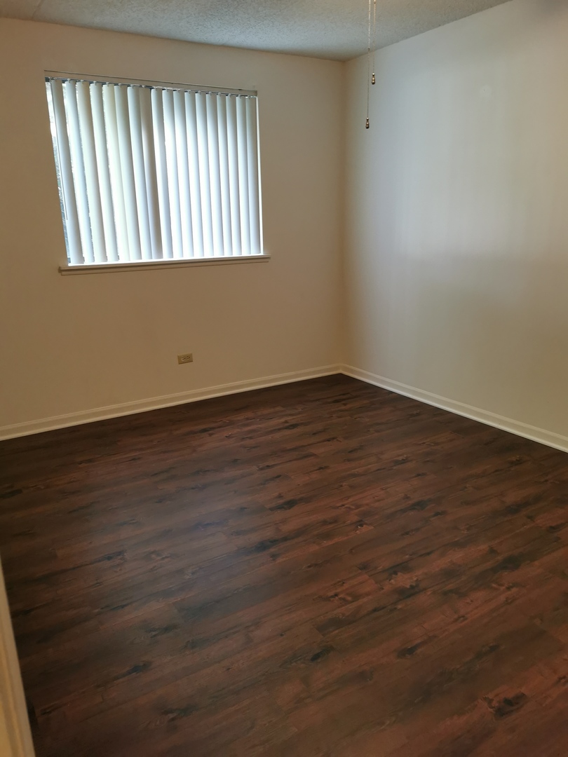 1424 Rock Run Drive, Unit B1 Crest Hill, IL 60403 - Photo 13 of 14 a view of an empty room with wooden floor and a window