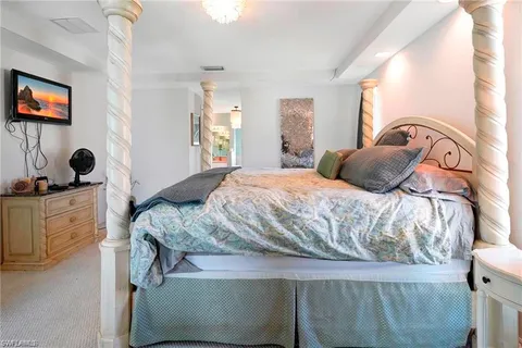 a bedroom with a bed and a chair with the view of bathroom