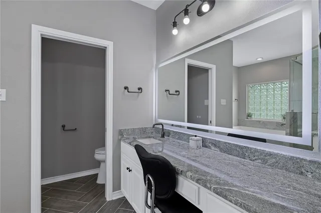 a bathroom with a granite countertop sink and a mirror