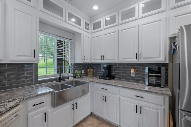 a kitchen with granite countertop a sink a stove and cabinets
