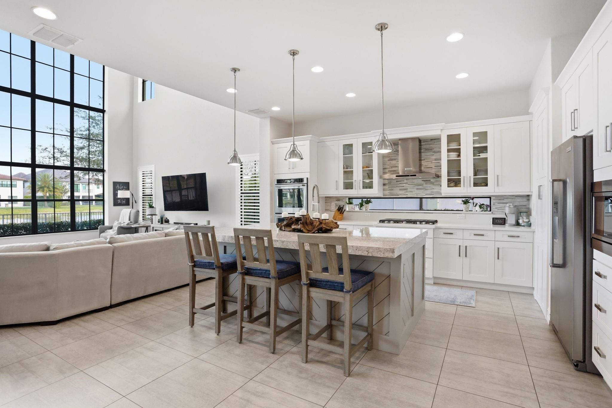 11585 Horizon Road Parkland, FL 33076 - Photo 5 of 91 a kitchen with stainless steel appliances kitchen island granite countertop a table chairs and a refrigerator