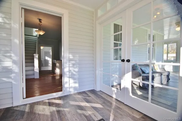 a view of a hallway with wooden floor and a living room