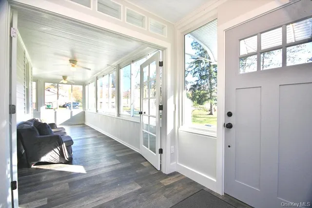 a living room with furniture floor to ceiling window and wooden floor