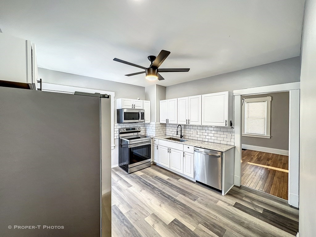 49 Hobson Street Springfield, MA 01109 - Photo 23 of 32 a kitchen with white cabinets and stainless steel appliances