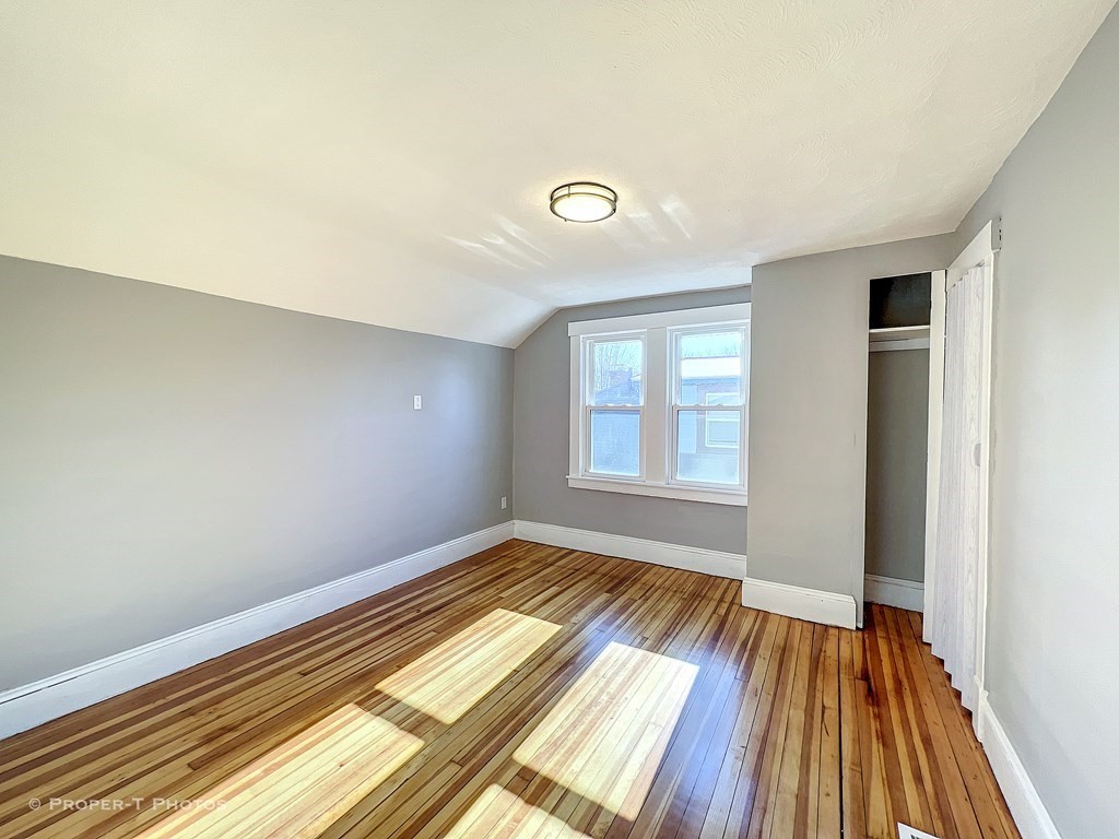 49 Hobson Street Springfield, MA 01109 - Photo 25 of 32 an empty room with wooden floor and windows