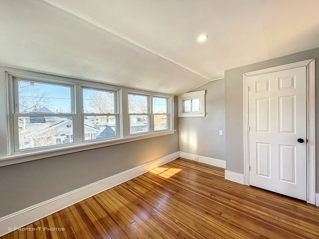 49 Hobson Street Springfield, MA 01109 - Photo 27 of 32 an empty room with wooden floor and windows