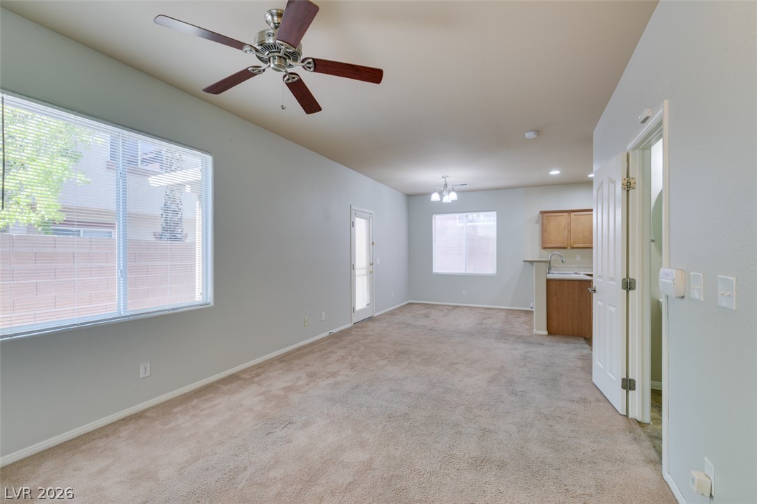 8937 Caledon Ridge Court Las Vegas, NV 89149 - Photo 4 of 43 A spacious living area with comfortable carpeting and abundant natural light offers a welcoming atmosphere.